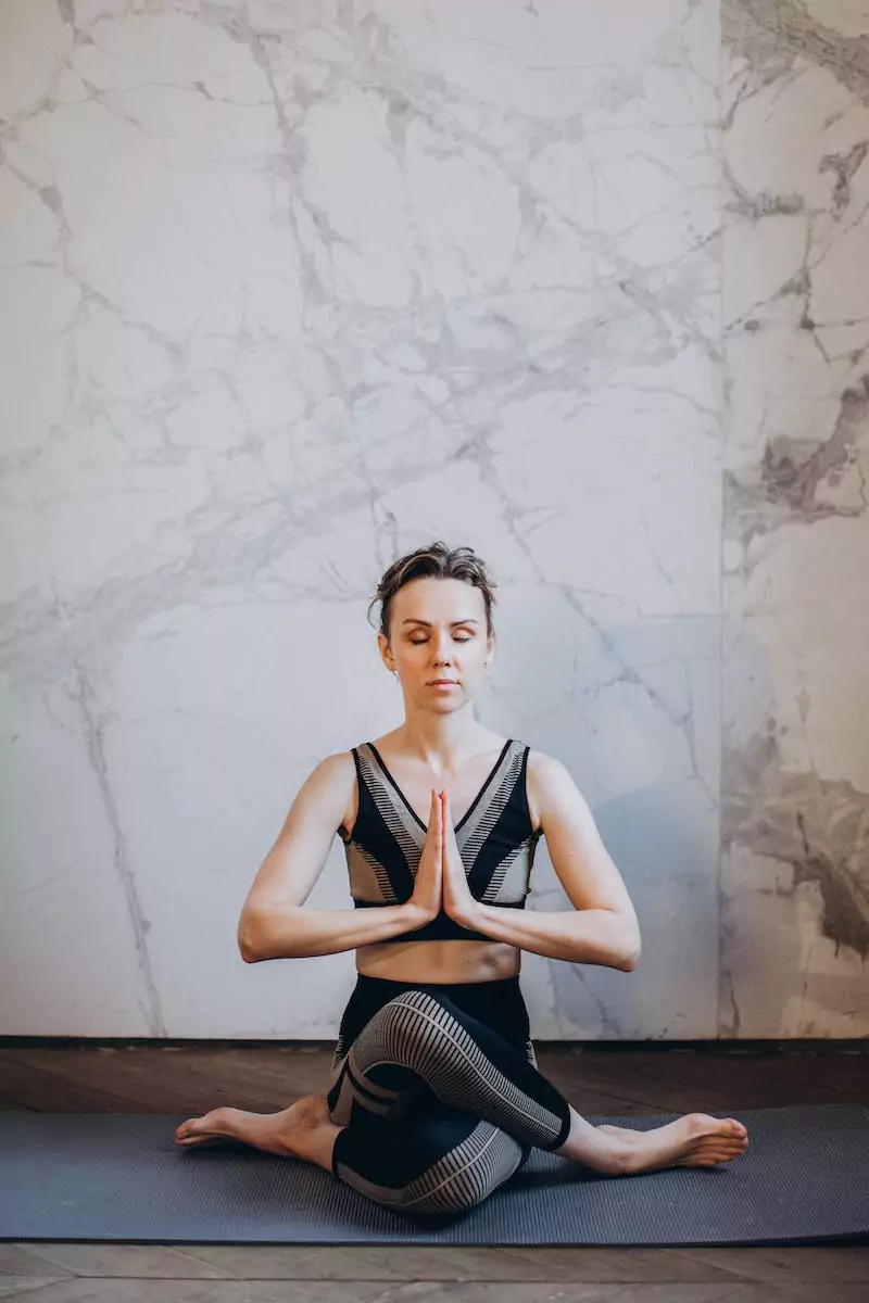 A lady sitting in a crosslegged yoga poses.